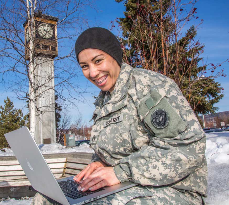 SSG Vanessa Collazo in downtown Fairbanks on a laptop