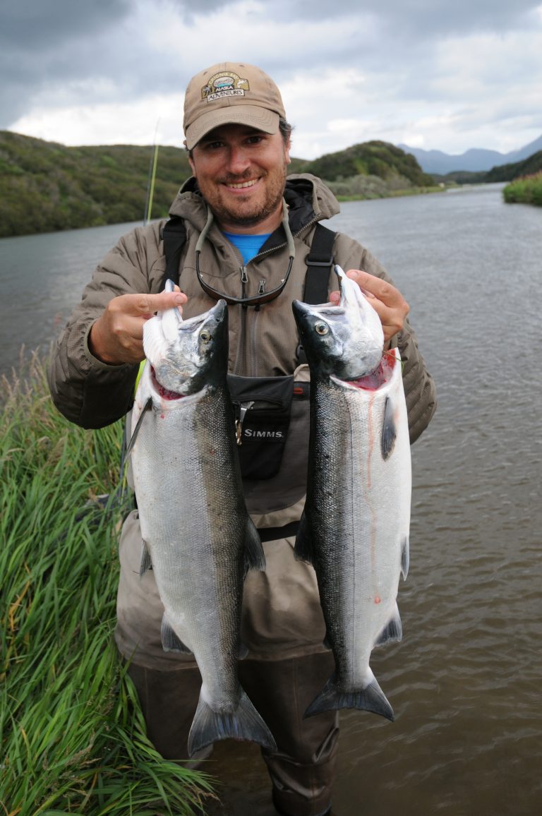 Photo of UAF Assistant Professor Peter Westley holding up two salmon